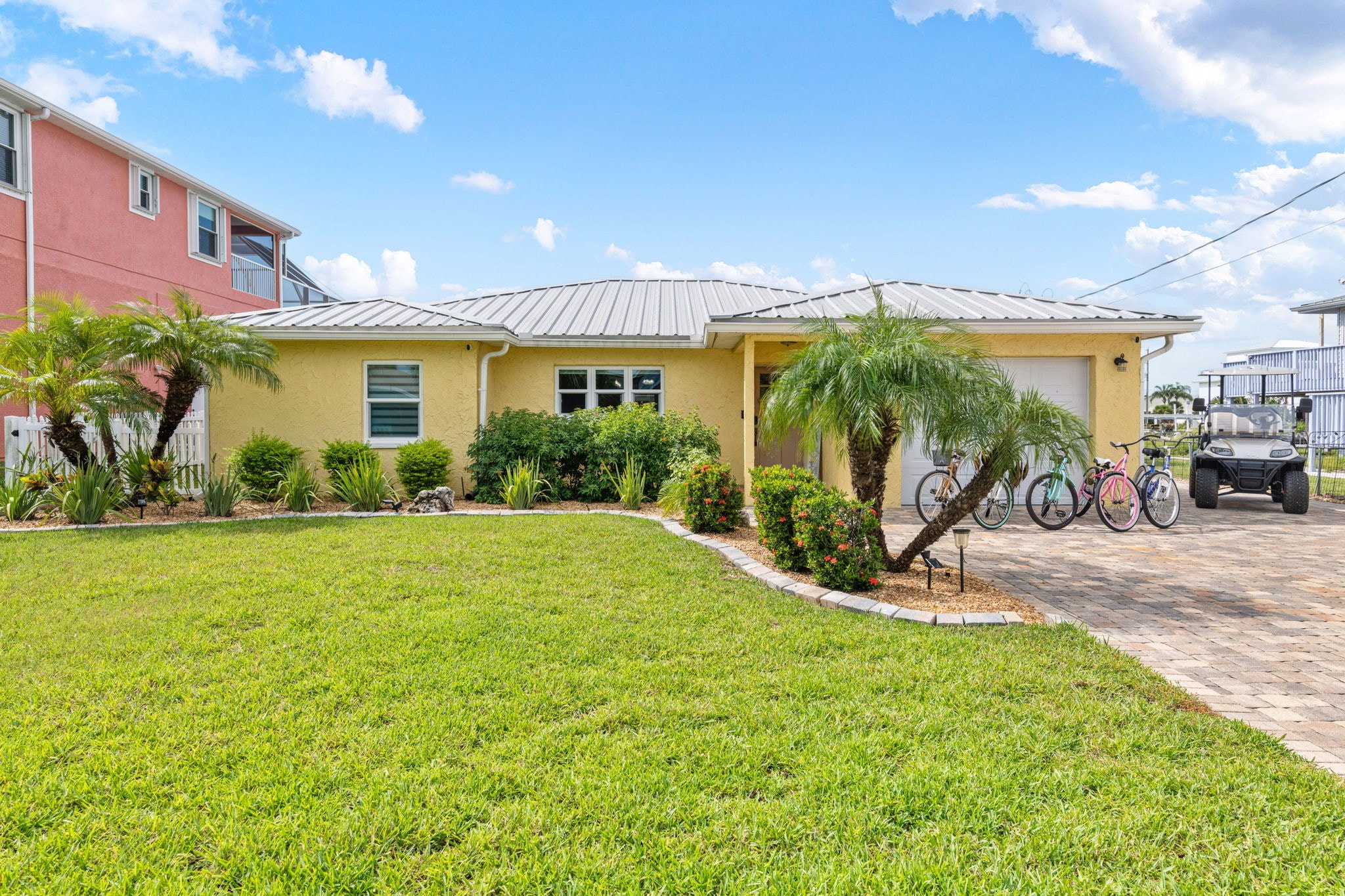 Yellow beach house exterior with palm trees