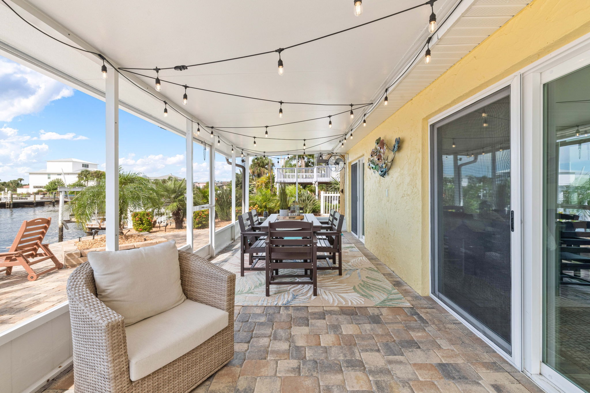 Backyard patio from dock level with tropical landscaping