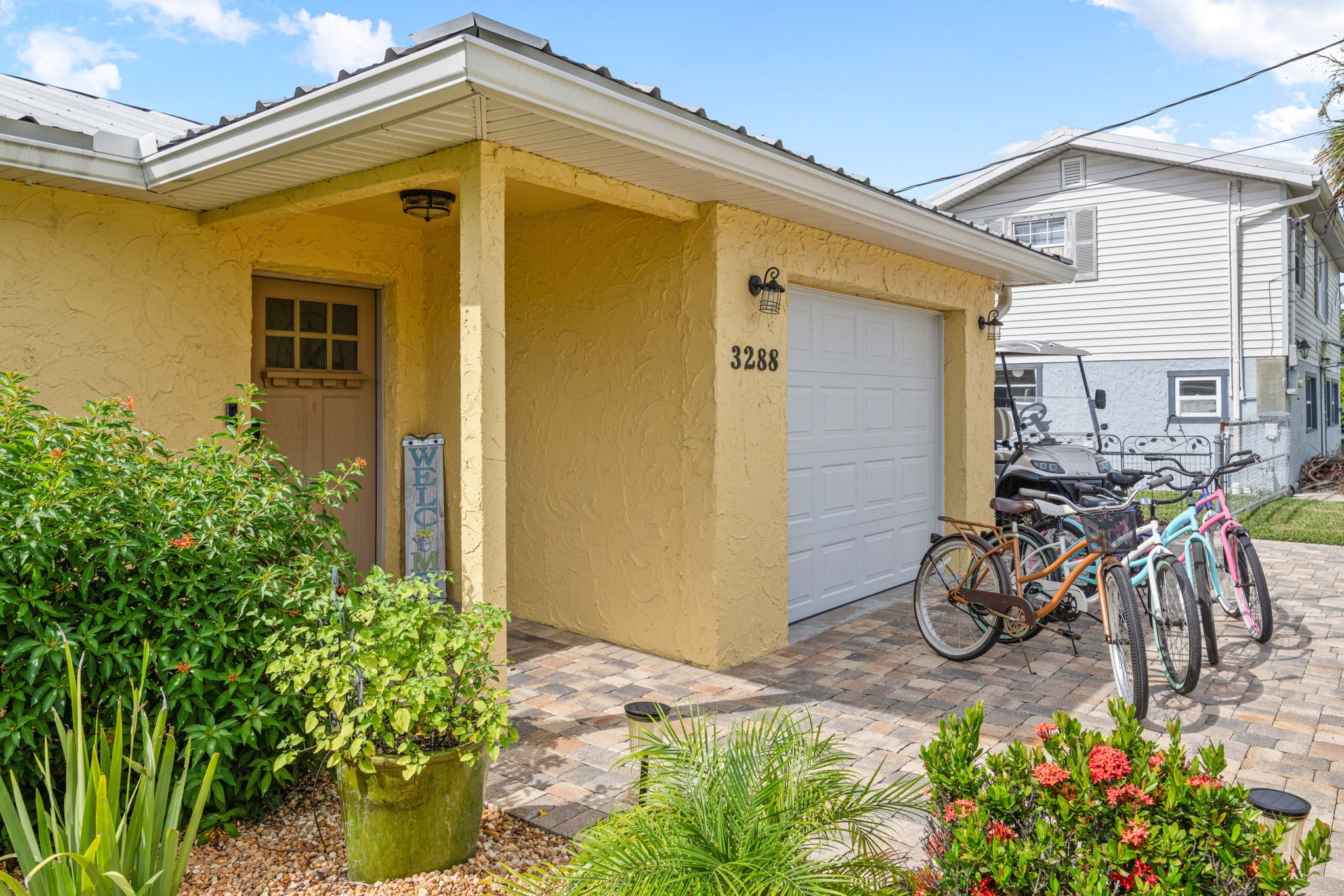 Yellow exterior with garage and bicycles